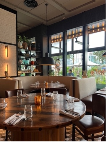 Interior of The Pearl Tampa with a dark wood table and booths in the background.