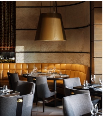 Meat Market Tampa restaurant seating featuring grey tables, chairs, and orange booth.